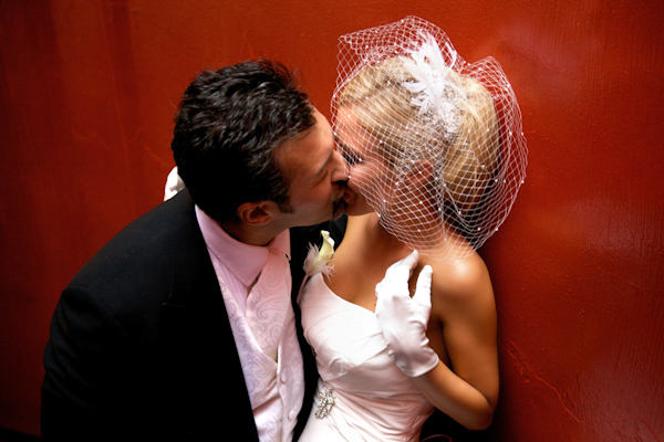 wedding photo by Bob and Dawn Davis Photography, bride and groom kissing, white gloves, white birdcage veil 